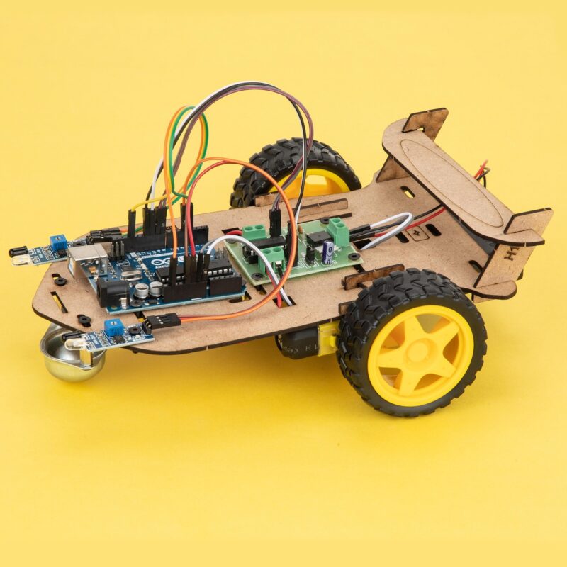 A coding robot with instruction cards laid out beside it